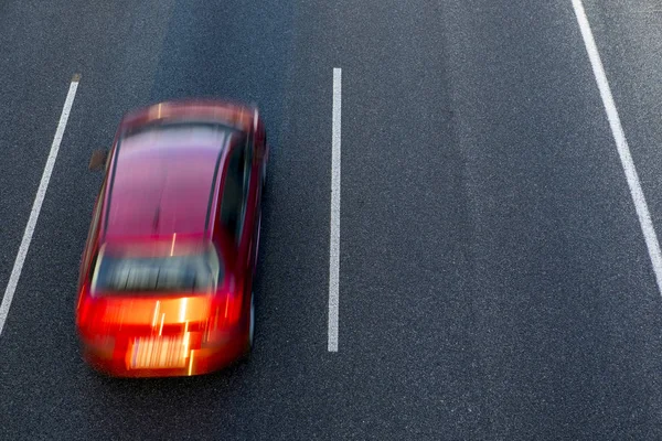 Czerwony Samochód Działa Szybko Autostrady Przez Lewego Pasa Zachodzie Słońca — Zdjęcie stockowe