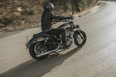 Klasik Motosiklet binici olan bir Amerikan klasik motosiklet yol dönüm yan görünüm