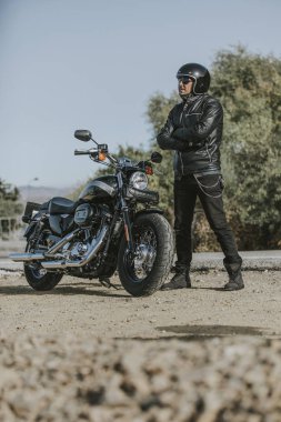 Onun motosiklet yakın poz siyah giysili adam.