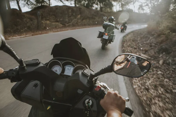 On board view of motorcycles turning on the road, from the point of view of the passenger.