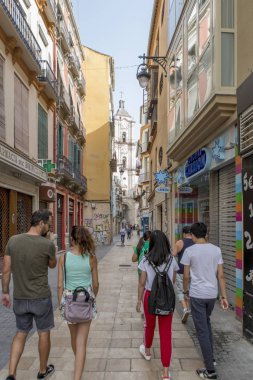 Malaga, İspanya - 2 Eylül 2018: Malaga, İspanya'nın şehir merkezinde bir yolculuk sırasında arasında dar bir şerit yürüyen turist.