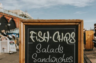 Blackboard restoran menü ve bilgi bir mesire ortasında, balık ve patates kızartması, salata, sandviç ve diğer gıda ile.