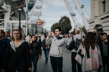 Londra, İngiltere - 25 Ekim, 2018: genç adam Londra'da güneşli bir günde Kraliçe nin yürüyüş, kalabalık içinde bir cep telefonu ile fotoğraf çekimi.