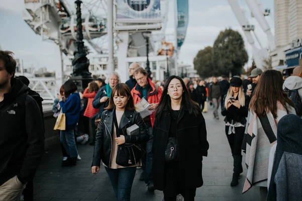 Londra, İngiltere - 25 Ekim, 2018: iki genç Asyalı kadınlar güneşli bir günde Londra, İngiltere'de Kraliçe nin yürüyüş arasında kalabalık içinde yürüyüş.