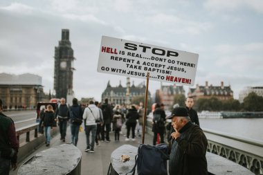 Londra, İngiltere - 25 Ekim, 2018: bir mesaj bir yönetim kurulu gösterilen bir eksantrik adam İsa'ya, Wetminster Köprüsü, ortasında turist etrafında, Londra, Birleşik Krallık ile ilgili.