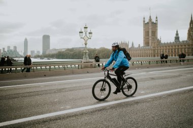 Londra, İngiltere - 25 Ekim, 2018: bir dağ bisikleti tarafından Westminster Bridge, Londra'nın arka planda Westminster Sarayı ile Birleşik Krallık kişini.