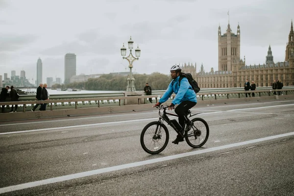 Londra, İngiltere - 25 Ekim, 2018: bir dağ bisikleti tarafından Westminster Bridge, Londra'nın arka planda Westminster Sarayı ile Birleşik Krallık kişini.