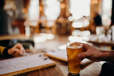 Adam el İngilizce bir barda bira ahşap bir tablodan bir yarım pint tutarak.