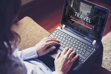 Seyahat acentası web sitesi bir dizüstü bilgisayar ve kadın evde Web'de gezinme.