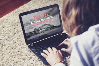 Seyahat acentası web sitesi kadın evde bir seyahat rezervasyon için kullandığı sırada bir laptop ekranında.