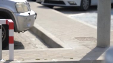 Park bariyer kaldırdı, bir araba cross sahne ve bariyer kapatır, doğal güneş ışığı ile bir açık havada park alanı.