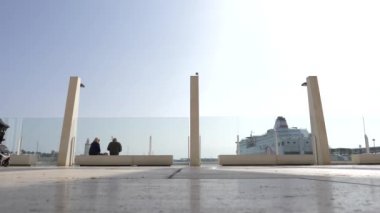 Malaga, İspanya - 21 Şubat 2019: Malaga bağlantı noktası promenade, mavi gökyüzü arka plan beyaz bir taş kaldırım boyunca güneşli bir gün ile tarafından yürüyüş sahne geçiş aile.