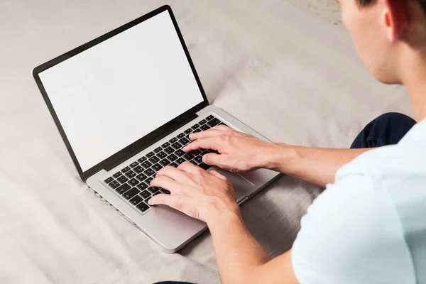 男子使用笔记本电脑坐在家里与白色空白屏幕 — 图库照片