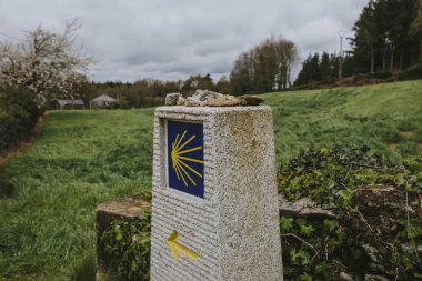 Sarı ok ve işaret ile, taştan yapılmış Camino de Santiago sonrası.