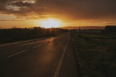 Arka planda giden bir araba ile gün doğumu sırasında Misterious yol.
