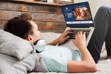 Bir dizüstü bilgisayar ile internet üzerinden bir e-öğrenme cankurtaran eğitimi yapıyor Adam.