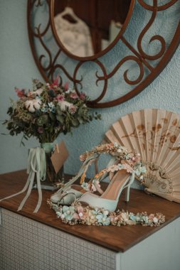 Gelin buketi ve ayakkabı bir masada.