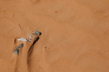 Plastik su şişesi kumda terk edilmiş. Kirlenme.