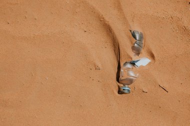Plastik su şişesi kumda terk edilmiş. Kirlenme.