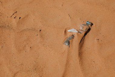 Plastik su şişesi kumda terk edilmiş. Kirlenme.