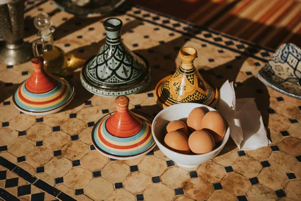 Boiled eggs and food in ceramic tajines. Moroccan breakfast.