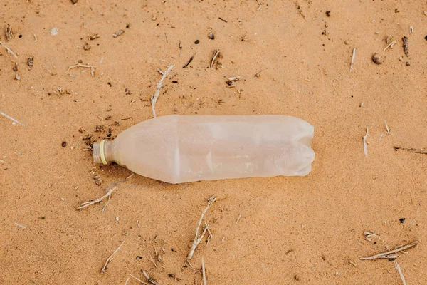 Plastic bottle abandoned in the sand. Contamination.