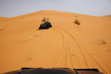 Çöldeki kum tepelerini aşan arazi arabaları. Saldırı macerası..