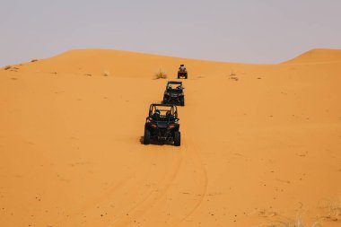Çöldeki kum tepelerini aşan arazi arabaları. Saldırı macerası..