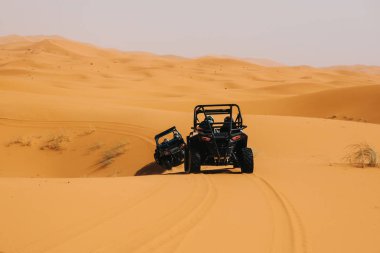 Çöldeki kum tepelerini aşan arazi arabaları. Saldırı macerası..