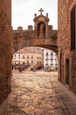 Caceres, İspanya - 23 Haziran 2020: Caceres Plaza Belediye Başkanı ve Arco de la Estrella 'nın güzel gün batımı ışığı ve terasta oturan turist manzarası.