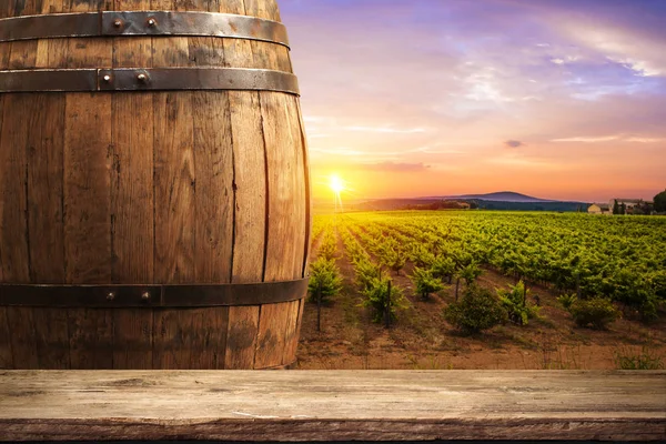 Red wine with barrel on vineyard in green Tuscany, Italy