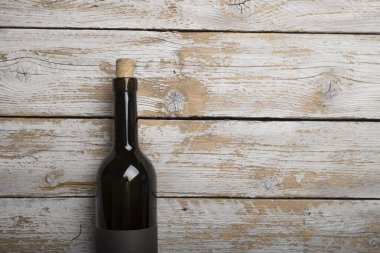 Kırmızı şarap ile bir tirbuşon bir şişe. Siyah bir ahşap arka plan üzerinde