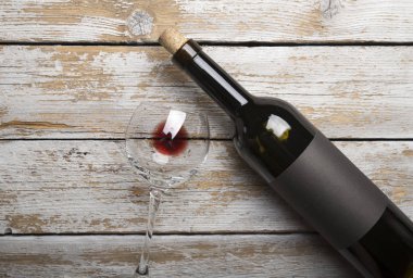 Kırmızı şarap ile bir tirbuşon bir şişe. Siyah bir ahşap arka plan üzerinde