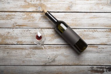 Kırmızı şarap ile bir tirbuşon bir şişe. Siyah bir ahşap arka plan üzerinde