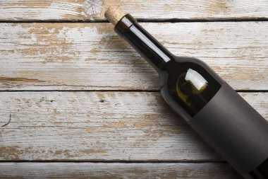 Kırmızı şarap ile bir tirbuşon bir şişe. Siyah bir ahşap arka plan üzerinde