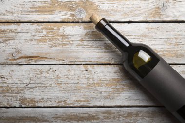 Kırmızı şarap ile bir tirbuşon bir şişe. Siyah bir ahşap arka plan üzerinde