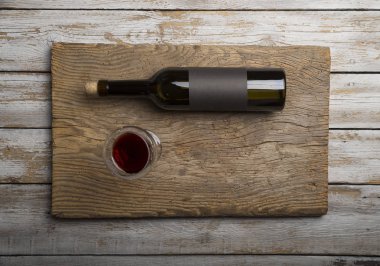 Kırmızı şarap ile bir tirbuşon bir şişe. Siyah bir ahşap arka plan üzerinde