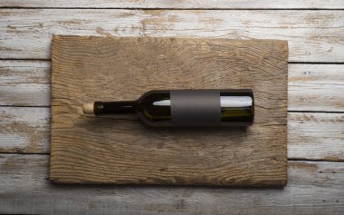 Kırmızı şarap ile bir tirbuşon bir şişe. Siyah bir ahşap arka plan üzerinde