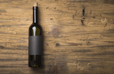 Kırmızı şarap ile bir tirbuşon bir şişe. Siyah bir ahşap arka plan üzerinde