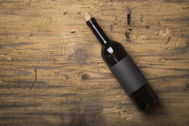 Kırmızı şarap ile bir tirbuşon bir şişe. Siyah bir ahşap arka plan üzerinde