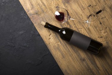 Kırmızı şarap ile bir tirbuşon bir şişe. Siyah bir ahşap arka plan üzerinde