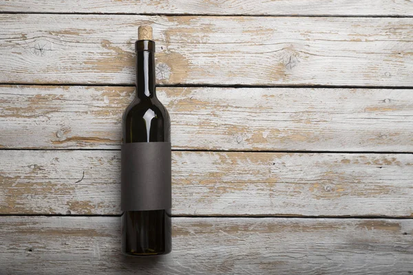 Kırmızı şarap ile bir tirbuşon bir şişe. Siyah bir ahşap arka plan üzerinde