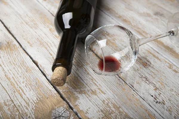 Kırmızı şarap ile bir tirbuşon bir şişe. Siyah bir ahşap arka plan üzerinde