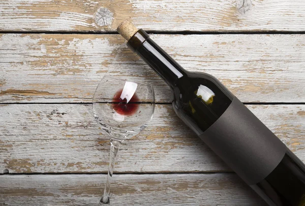 Kırmızı şarap ile bir tirbuşon bir şişe. Siyah bir ahşap arka plan üzerinde