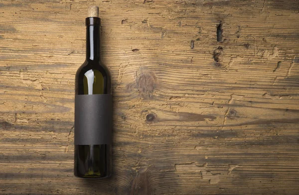 Kırmızı şarap ile bir tirbuşon bir şişe. Siyah bir ahşap arka plan üzerinde