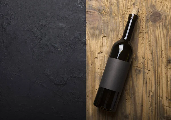 Kırmızı şarap ile bir tirbuşon bir şişe. Siyah bir ahşap arka plan üzerinde