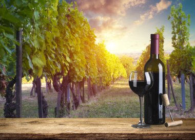 Kırmızı şarap şişesi ve yün fıçıda şarap kadehi. Güzel Toskana arka planı