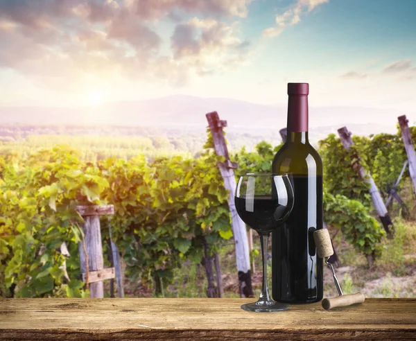 Kırmızı şarap şişesi ve yün fıçıda şarap kadehi. Güzel Toskana arka planı