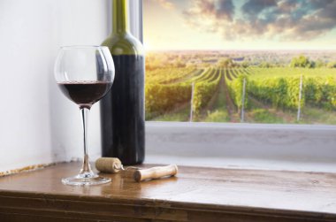 kırmızı şarap şişesi ve şarap kadehi yün fıçıda.