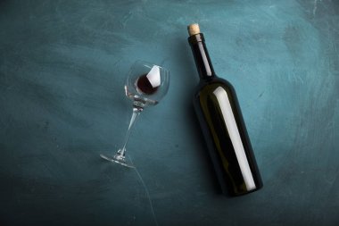 Kırmızı şarap kadehleri ve taş arka planda bir şişe. Kopyalama alanı olan üst görünüm